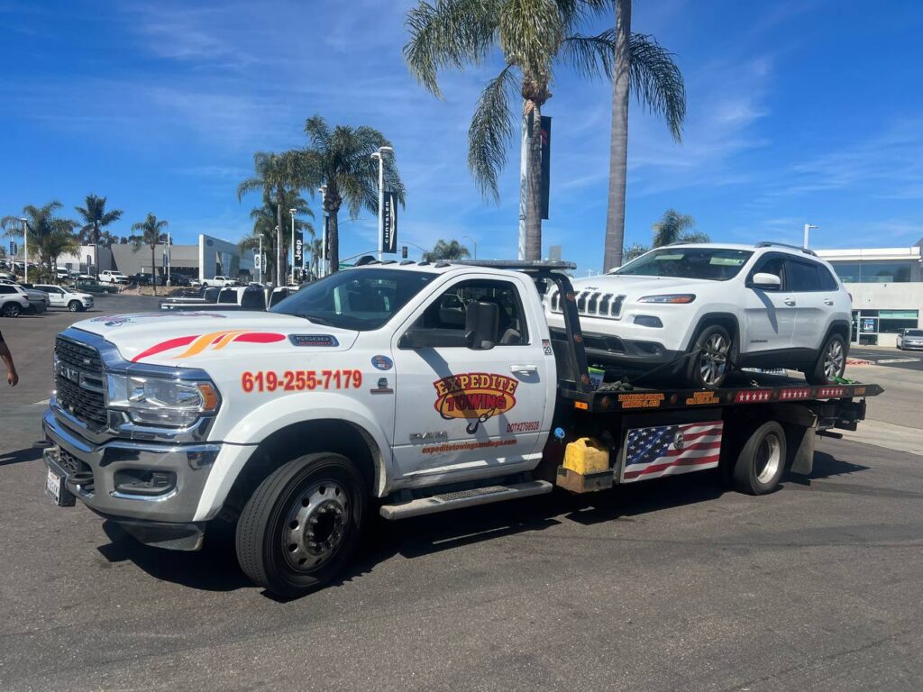 White Jeep Car on Flatbed tow truck in San Diego